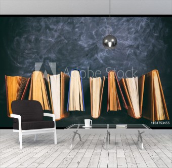 Picture of Vintage books standing on blackboard background - top view